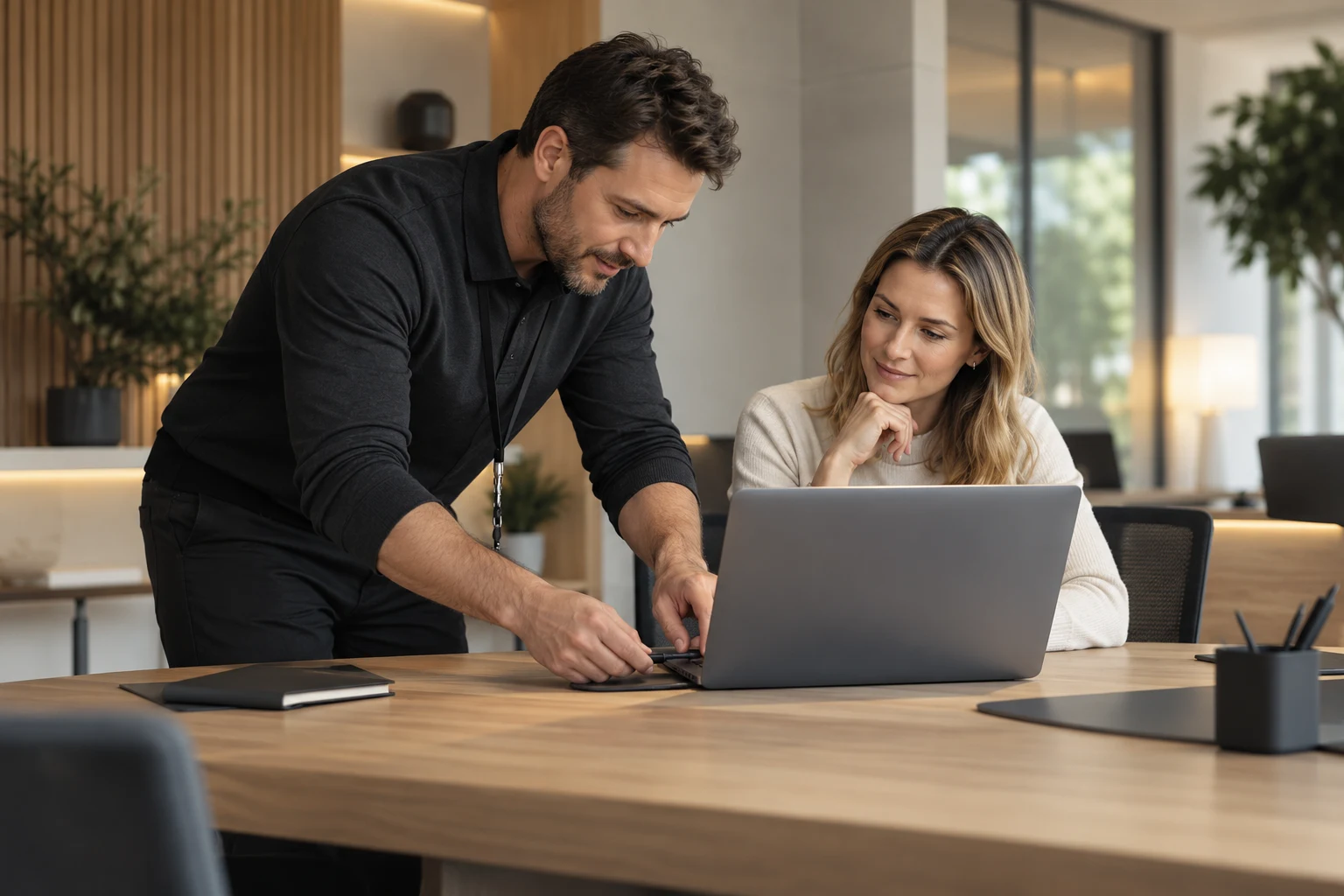 IT technician helping a colleague with a laptop